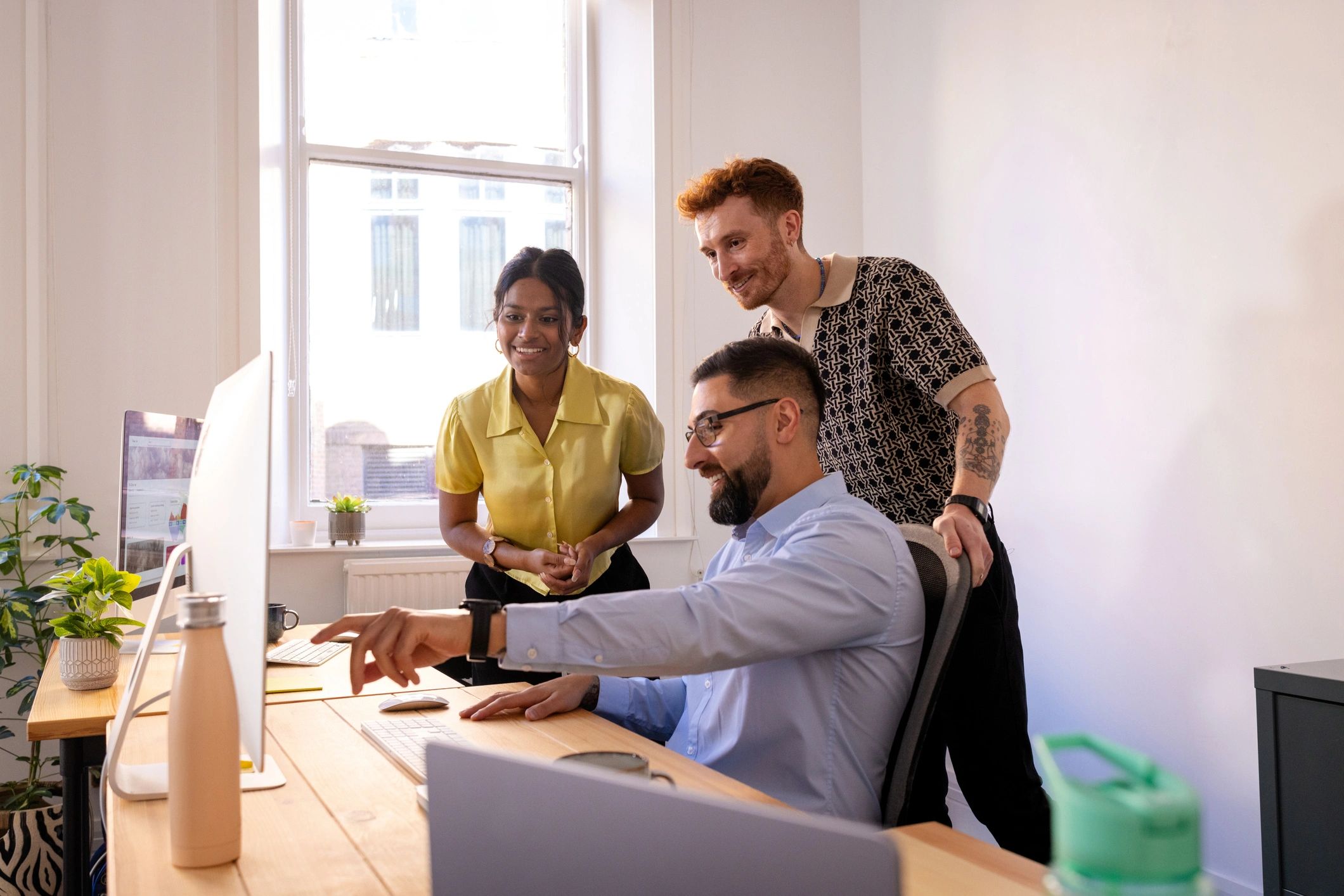 Technology team collaborating around a computer